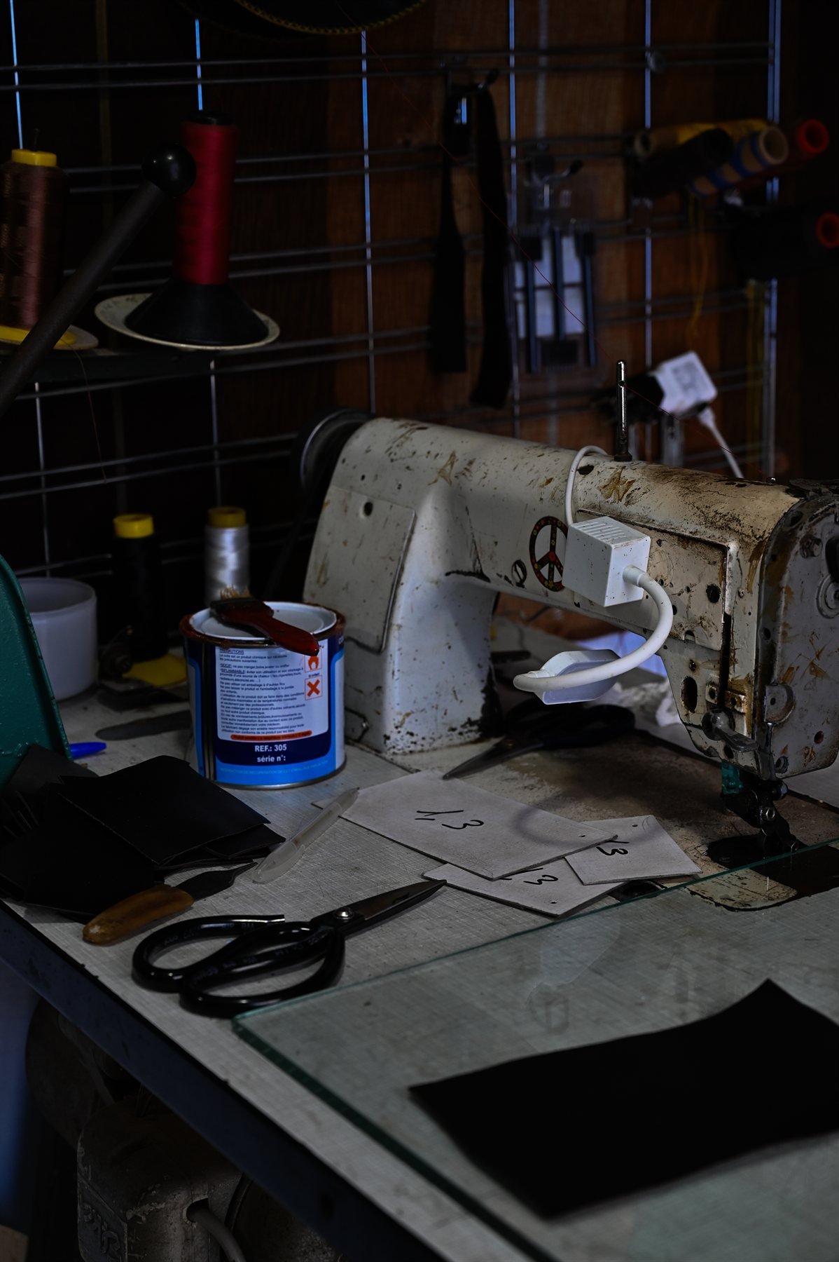 Établi d'un atelier de sellerie avec ciseaux et pièces de cuir