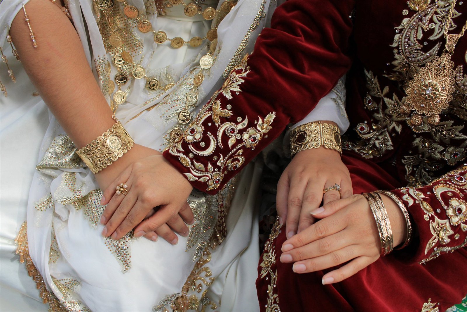 Mains de mariées en tenue traditionnelle, bracelets d'or
