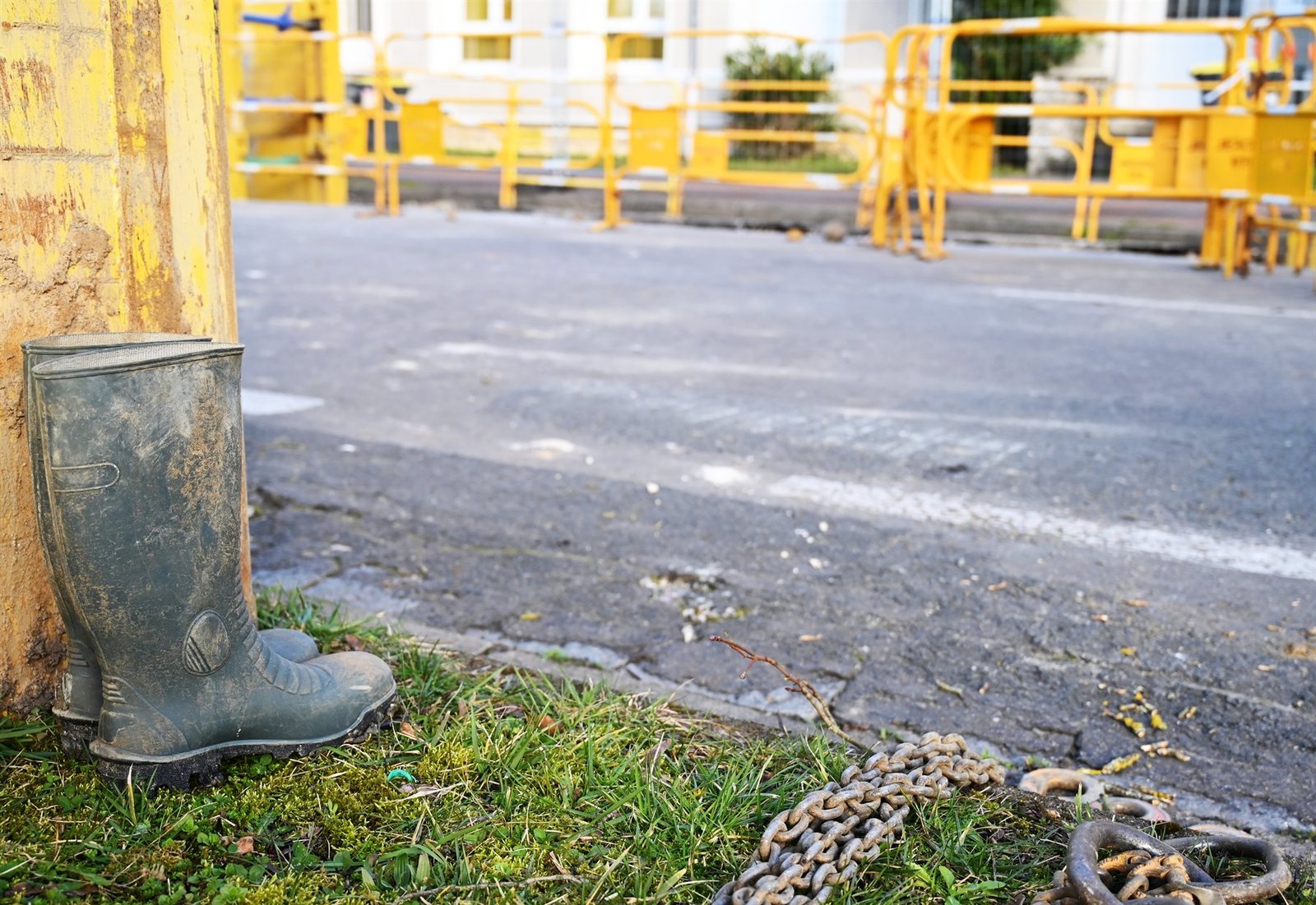 Bottes et chaîne posées au bord d'une chaussée en travaux