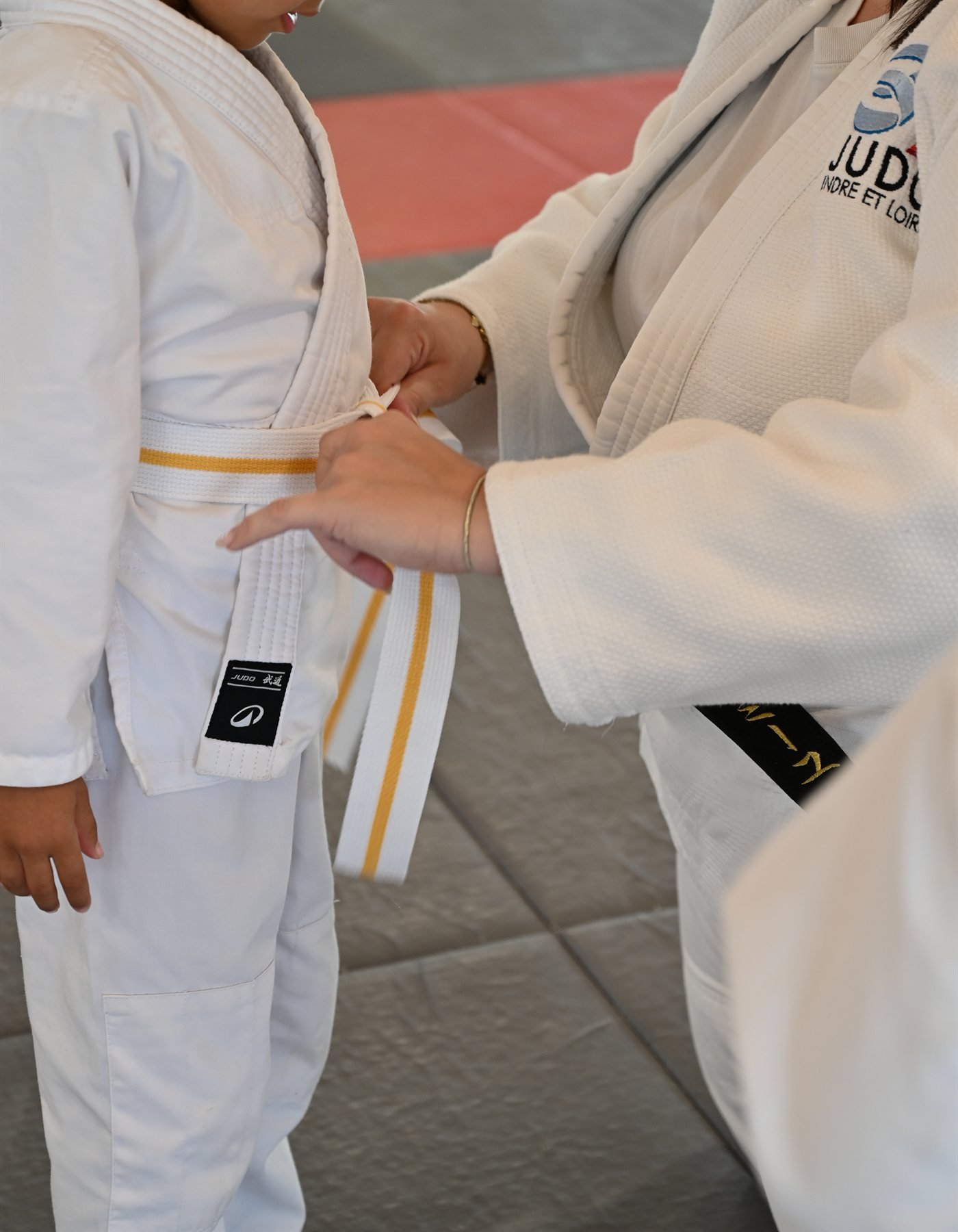 Ceinture jaune nouée sur un judogi d'enfant