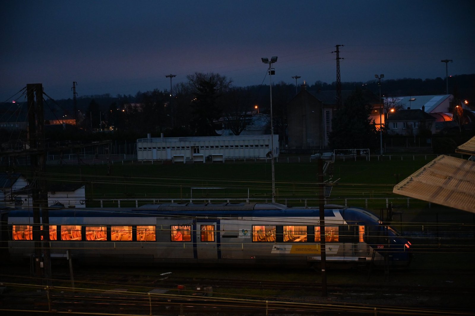 Train aux fenêtres éclairées à la tombée du jour