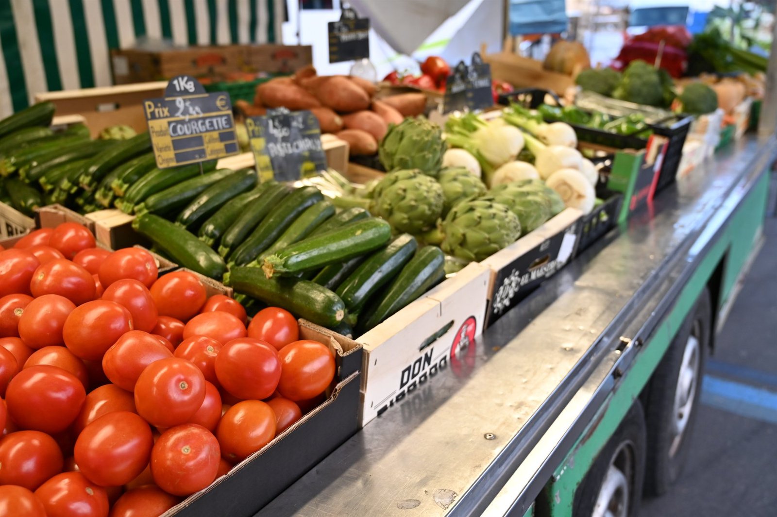 Étal de tomates, courgettes et choux-fleurs sur un marché