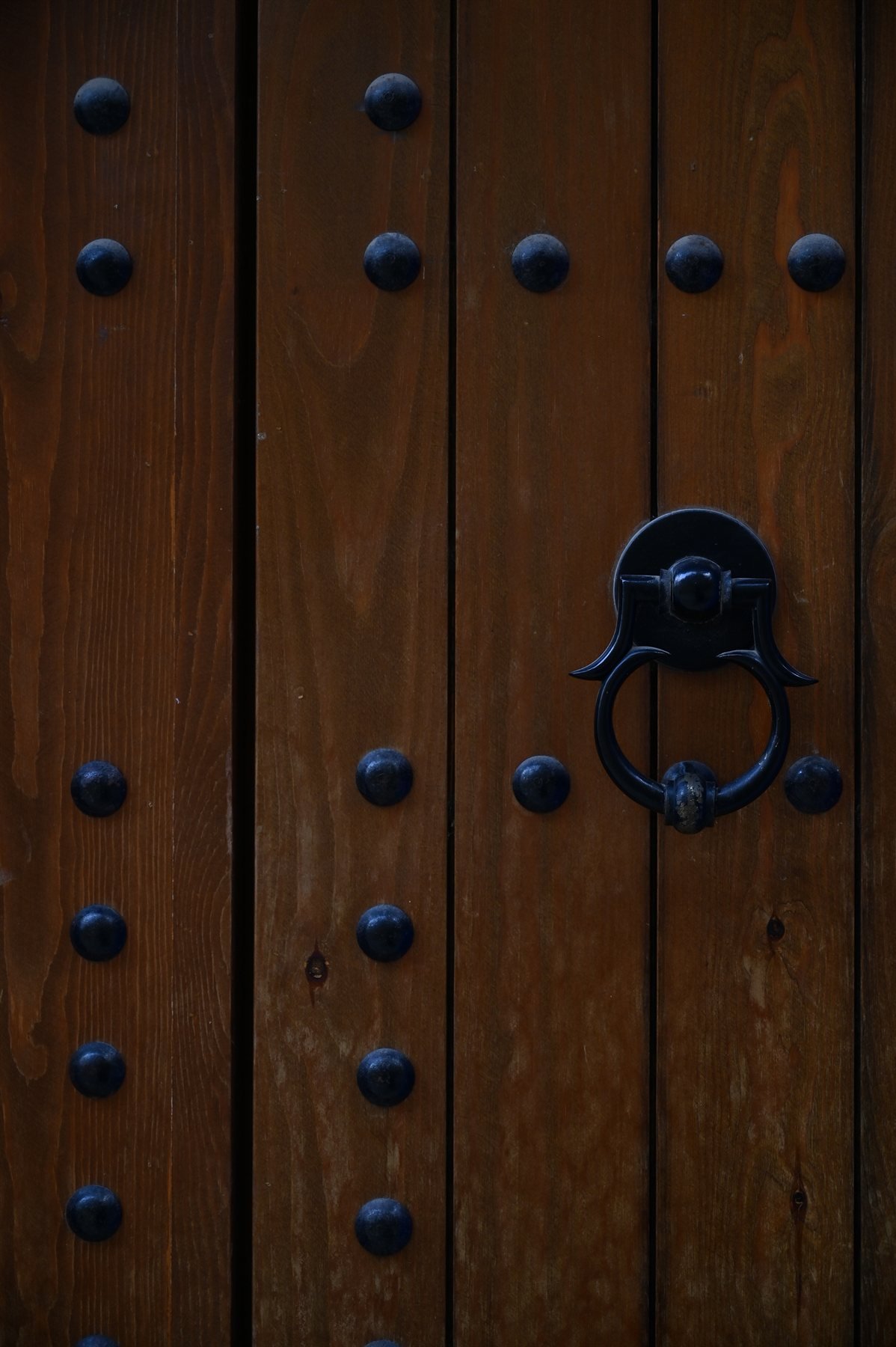 Porte en bois cloutée et heurtoir en forme de main