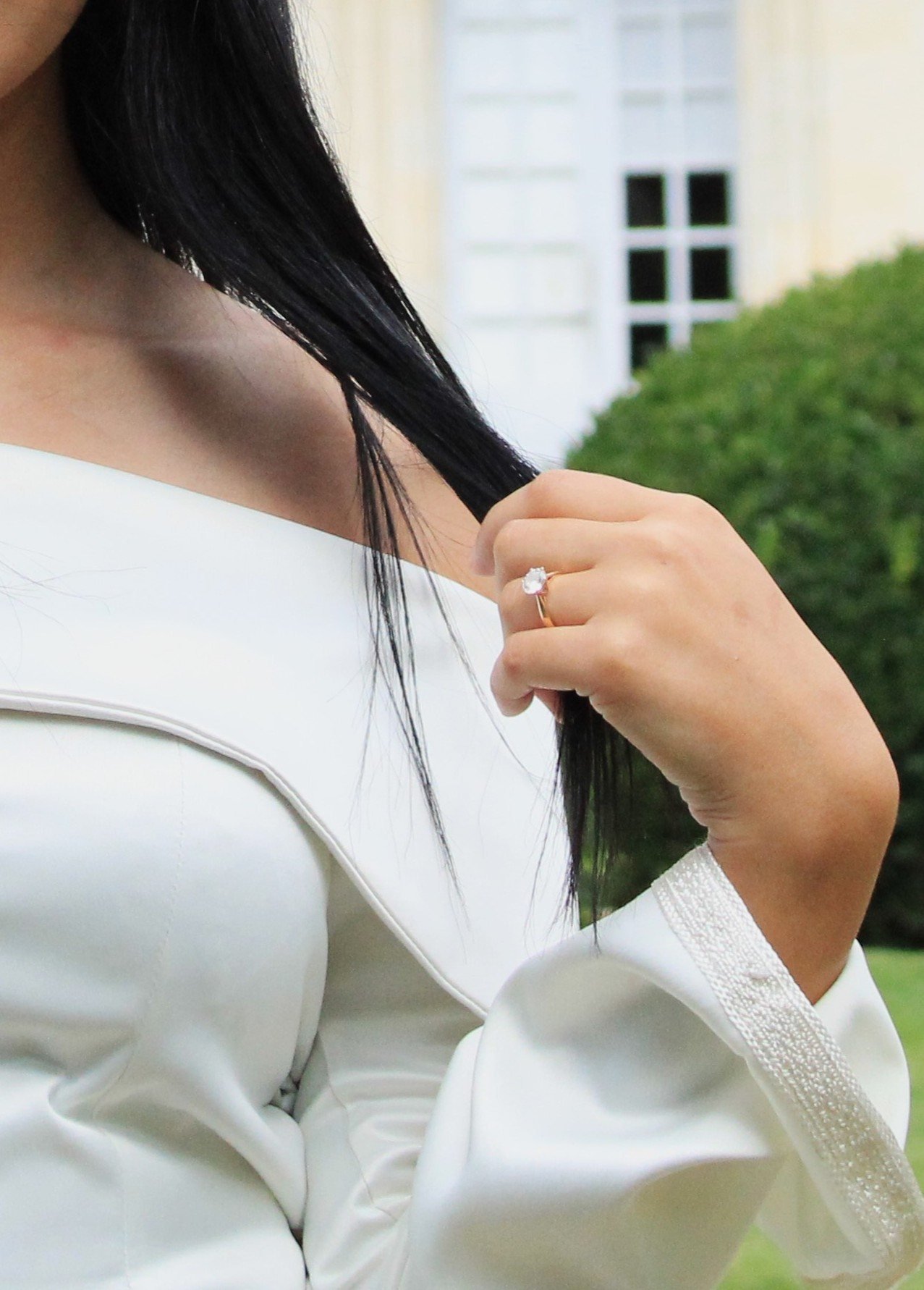 Détail d'une tenue blanche, mains dans les cheveux