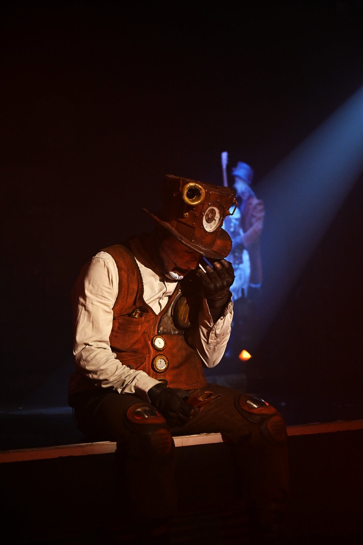 Comédien assis dans une lumière rouge de scène