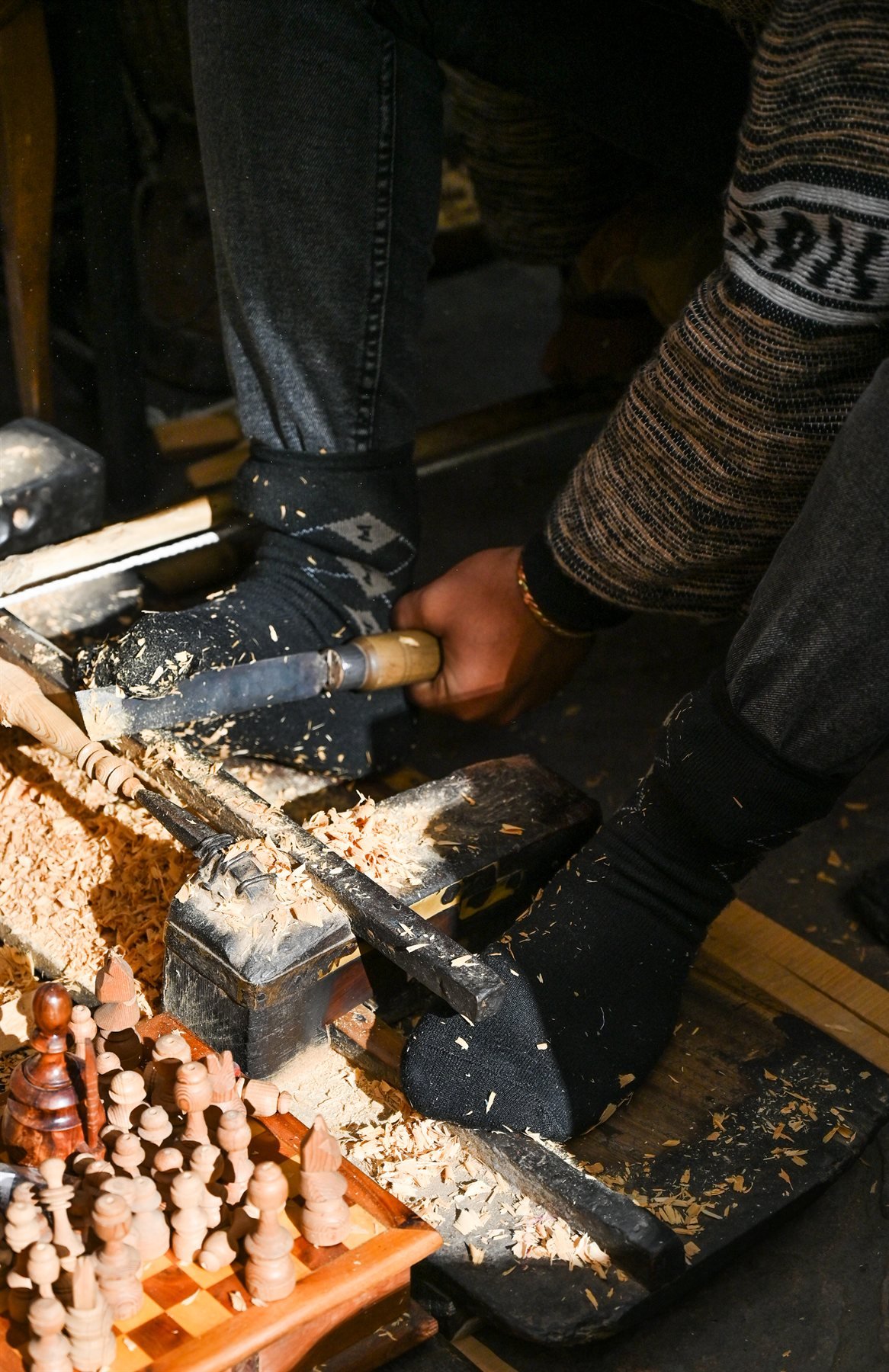 Tourneur sur bois au travail, copeaux et pièces tournées