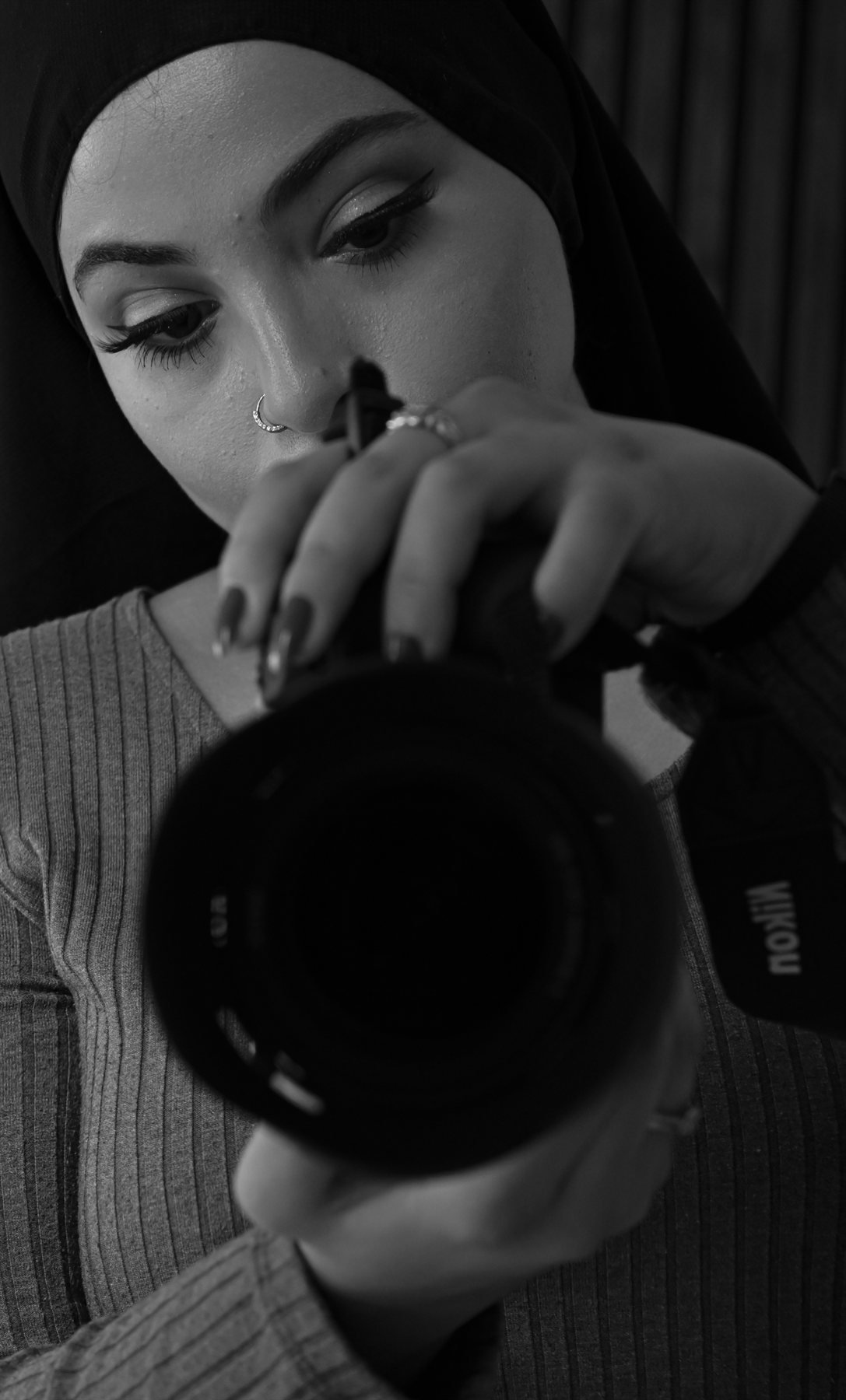 Wiam, photographe reporter à Tours, tenant son appareil photo, noir et blanc